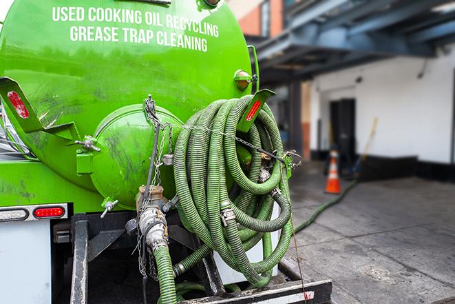 a grease trap being pumped by a sanitation technician in Wallingford